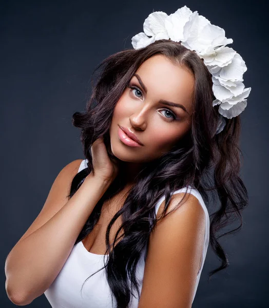 Vacker brunett kvinna med blomma hårband poserar i studion — Stockfoto