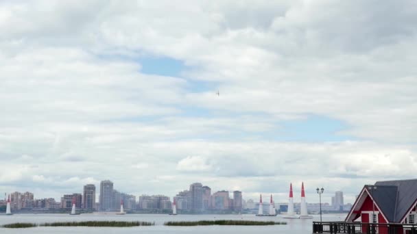 一架小型飞机在城市上空做着不同的环行 翻滚和其他的壮举来取悦观众 天空灰蒙蒙的 — 图库视频影像