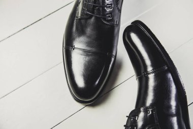 Siyah erkek deri ayakkabıları bir beyaz tahta üzerinde