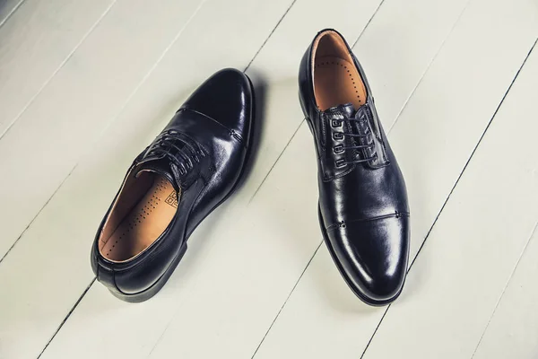 Black men's leather shoes on a white board — Stock Photo, Image