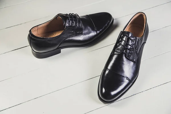 Zapatos de cuero negro para hombre en una pizarra blanca —  Fotos de Stock