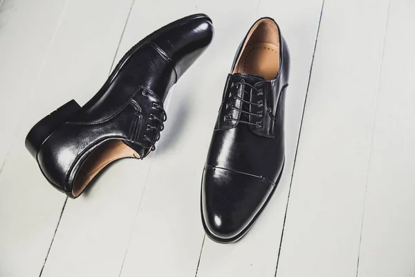 Chaussures en cuir noir pour hommes sur un tableau blanc — Photo