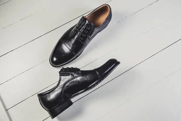 Chaussures en cuir noir pour hommes sur un tableau blanc — Photo