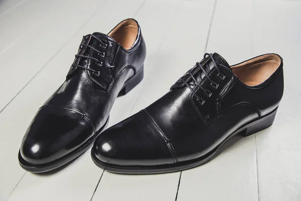 Chaussures en cuir noir pour hommes sur un tableau blanc — Photo