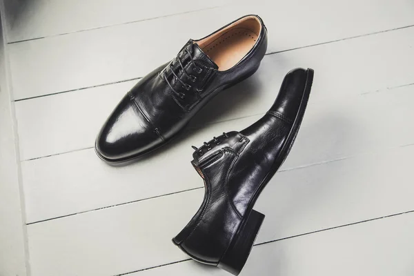 Zapatos de cuero negro para hombre en una pizarra blanca — Foto de Stock