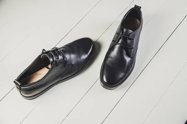 Chaussures en cuir noir pour hommes sur un tableau blanc — Photo