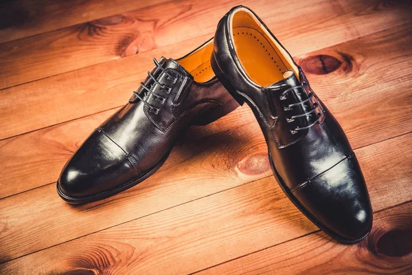 Zapatos de hombre de cuero negro sobre fondo de madera — Foto de Stock