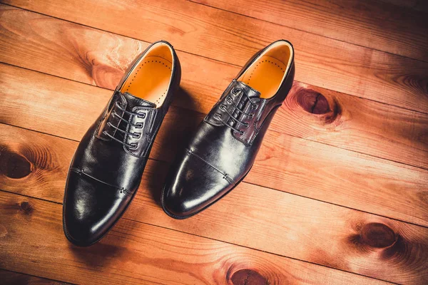 Zapatos de hombre de cuero negro sobre fondo de madera — Foto de Stock