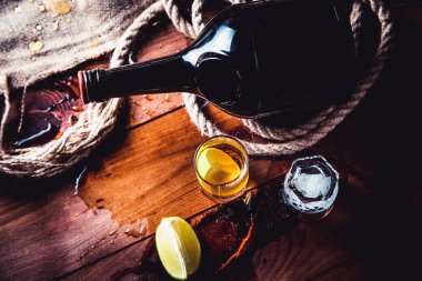 Bir şişe viski, ROM, brendi, bir ahşap zemin üzerine kireç