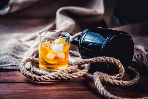 Eine Flasche Whiskey, Rum, Brandy, Limette auf einem hölzernen Hintergrund — Stockfoto