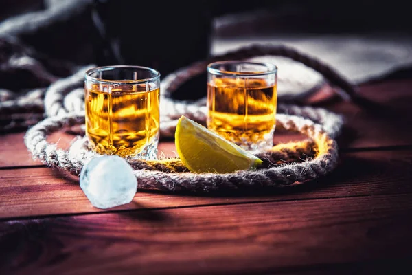 ボトル ウイスキー、ラム酒、ブランデー、木製の背景にライム — ストック写真
