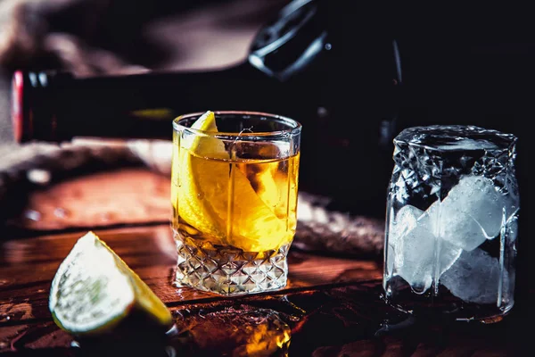 ボトル ウイスキー、ラム酒、ブランデー、木製の背景にライム — ストック写真