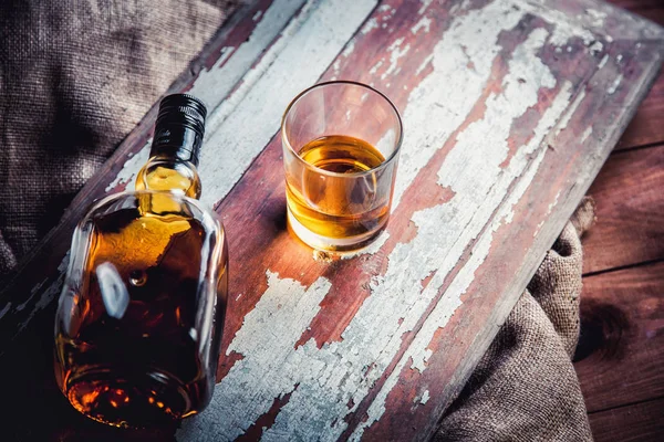 Whisky fles en glas op een houten vintage achtergrond — Stockfoto