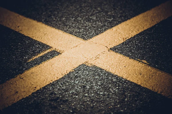 Cruz amarilla en el pavimento — Foto de Stock