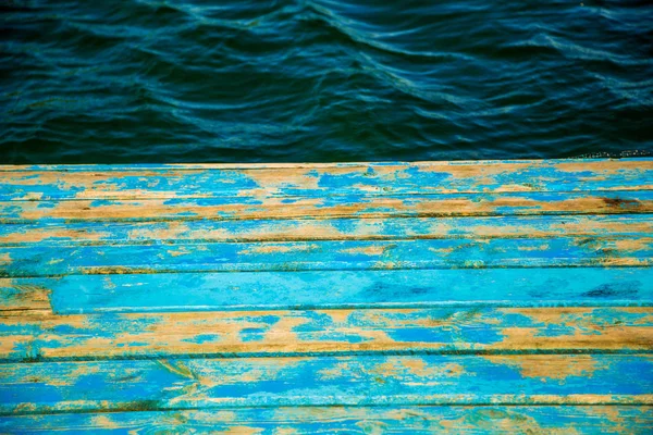 Denizin arka planında eski püskü mavi iskele — Stok fotoğraf