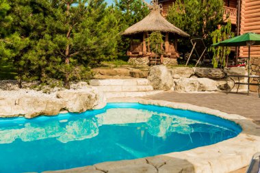 Bahçenin arka bahçesindeki havuzda mavi su manzarası.