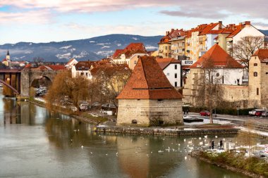 Slovenya 'nın Maribor şehrindeki Eski Su Kulesi Vodni Stolp. Ortaçağ güçlendirilmiş kule manzarası, Drava nehri üzerindeki Eski Devlet köprüsü ve kuğular