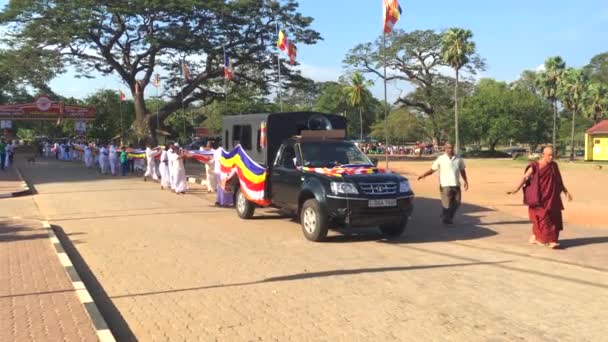 ANURADHAPURA, SRI LANKA - 15 июля 2017 - Группа буддийских паломников, исполняющих церемонию Капрука Пуджава вокруг базы Руванвелисия Дагоба, 4k видео — стоковое видео