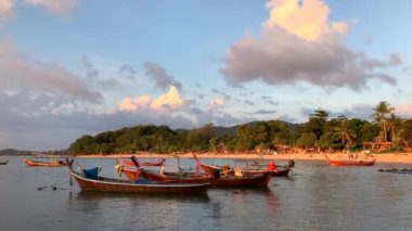 Koh Lanta, Tayland 'da geleneksel uzun kuyruklu teknelerle gün batımı.