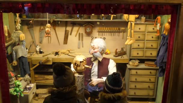 Duas crianças irreconhecíveis no inverno assistindo a um teatro de rua no mercado de natal na Europa — Vídeo de Stock