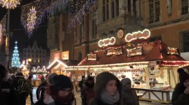 Mutlu Aile, insanlar eğleniyor, geceleri Noel Fuarı 'nda yemek yiyorlar. Renkli Noel ışıkları dekorasyonu, Wroclaw 'daki kalabalık, Polonya 2018