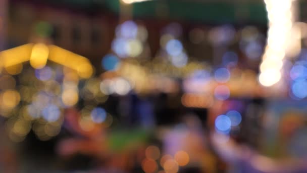 Iluminación festiva de la calle, luces borrosas de un pueblo de Navidad caminando en el fondo — Vídeo de stock