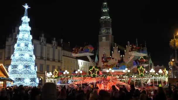 Família feliz, pessoas se divertindo, comendo na Feira de Natal à noite. Luzes de Natal coloridas decoração, multidão pessoas na cidade velha Wroclaw, Polônia 2018 — Vídeo de Stock