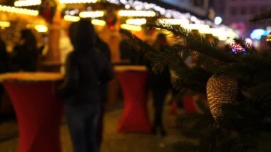 Avrupa 'da gece vakti Noel pazarı. Arka plandaki mavi insanlar. Renkli dekorasyon, mutlu aile zamanı.