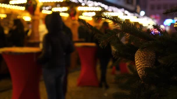 Рождественский рынок в ночное время в Европе. Размытые люди в прошлом. Красочные украшения, счастливое семейное время — стоковое видео