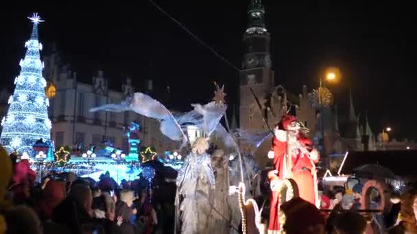 Традиционный парад Санта Клауса и эльфа на открытии рождественских праздников. Рождественская ярмарка ночью. Красочные огни украшения, толпа людей в старом городе Вроцлав, Польша 2018 — стоковое видео