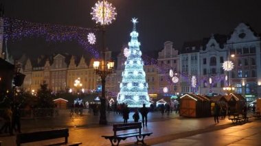 Mutlu Aile, insanlar eğleniyor, geceleri Noel Fuarı 'nda yemek yiyorlar. Renkli Noel ışıkları dekorasyonu, Wroclaw 'daki kalabalık, Polonya 2018