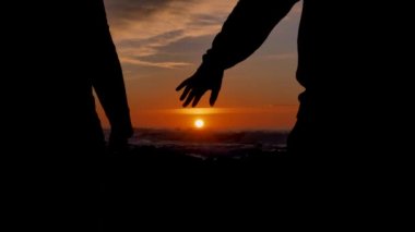 Slow motion couple joining hands together with sunlight in background. The suns rays shine through their fingers. Winner Love, Happiness and Friendship. Hands close up