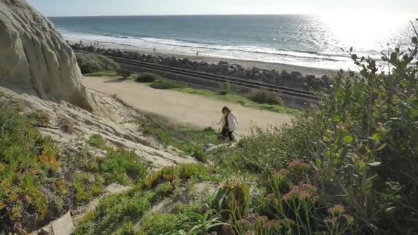 Aktív Senior nő sétál gyalogos ösvényen, közel az óceánhoz, gyönyörű tájakkal a nyári napon Kalifornia San Clemente calafia strandon. narancs megye életmód — Stock videók