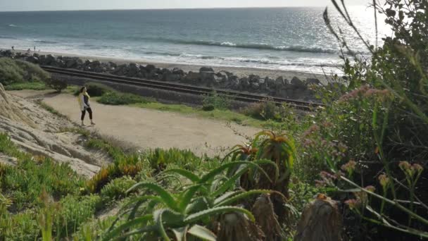 Femme âgée active marchant sur le sentier piétonnier près de l'océan avec de beaux paysages lors de la journée d'été en Californie san clemente calafia plage. mode de vie orange comté — Video