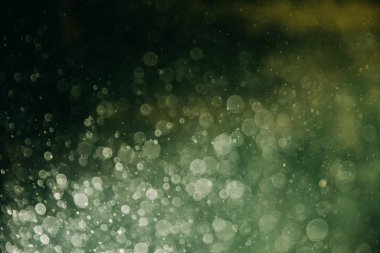 Duvar kağıdı için soyut arkaplan. Suda bir sürü çözülmüş baloncuk var. Akvaryum bokeh yeşil renklerde.