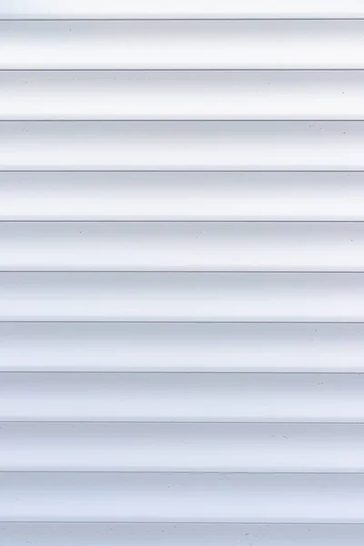 Roller shutter texture. Background with metal stripes in white. Iron roller shutters of white color. Abstract background for wallpaper in the form of straight lines.