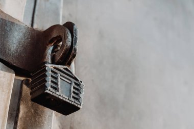 Kulübe şeklinde asma kilit kapalı kapının menteşelerinde asılı duruyor. Metal kapılar.