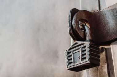 Kulübe şeklinde asma kilit kapalı kapının menteşelerinde asılı duruyor. Metal kapılar.