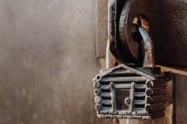 Kulübe şeklinde asma kilit kapalı kapının menteşelerinde asılı duruyor. Metal kapılar.