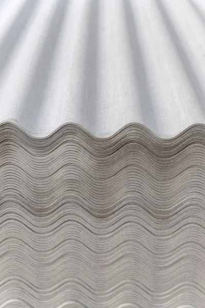 Many gray slate sheets are stacked on top of each other. Wavy stripes pattern