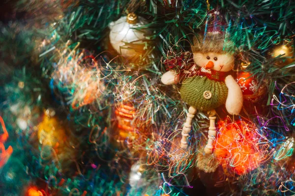 Świąteczna Zabawka Postaci Bałwana Wisi Sztucznej Choince Kolorowymi Jasnymi Światłami — Zdjęcie stockowe