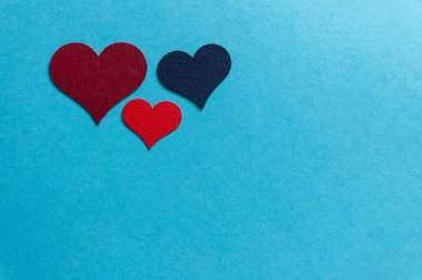 Mavi arka planda üç farklı kalp..