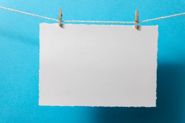 Mavi arka planda küçük mandalları olan boş kartpostalları işaretle.