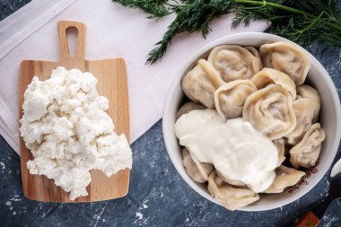 Mavi ahşap bir masanın üzerinde bir tabak haşlanmış hamur köftesi duruyordu.