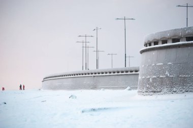 Körfez kıyısında karla kaplı şehir seti. 