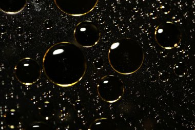 Su siyah zemin üzerinde Bokeh fi ile altın yağ kabarcıkları makro