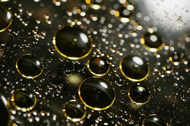 Su siyah zemin üzerinde Bokeh fi ile altın yağ kabarcıkları makro