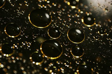 Su siyah zemin üzerinde Bokeh fi ile altın yağ kabarcıkları makro