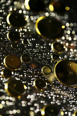Su siyah zemin üzerinde Bokeh fi ile altın yağ kabarcıkları makro