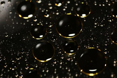 Su siyah zemin üzerinde Bokeh fi ile altın yağ kabarcıkları makro